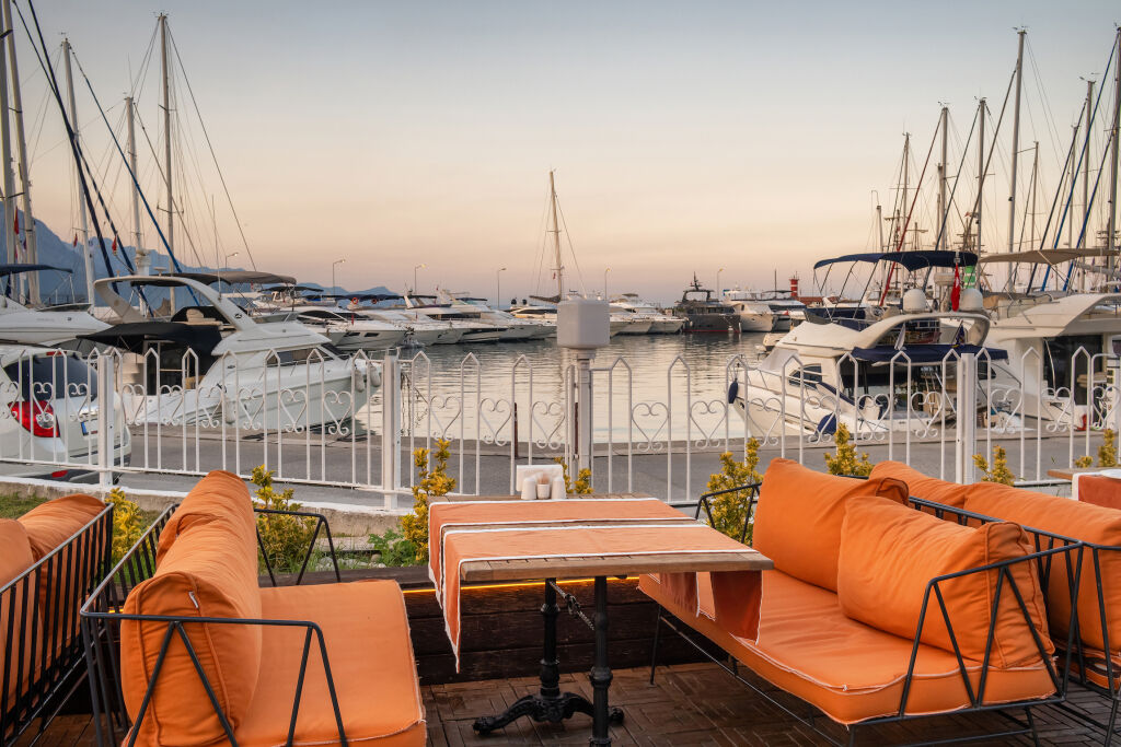 Przytulna kawiarnia na świeżym powietrzu w porcie miasta kurortu Kemer w prowincji Antalya, Morze Śródziemne, Turcja. Przytulna restauracja na świeżym powietrzu o zmierzchu w Kemer.