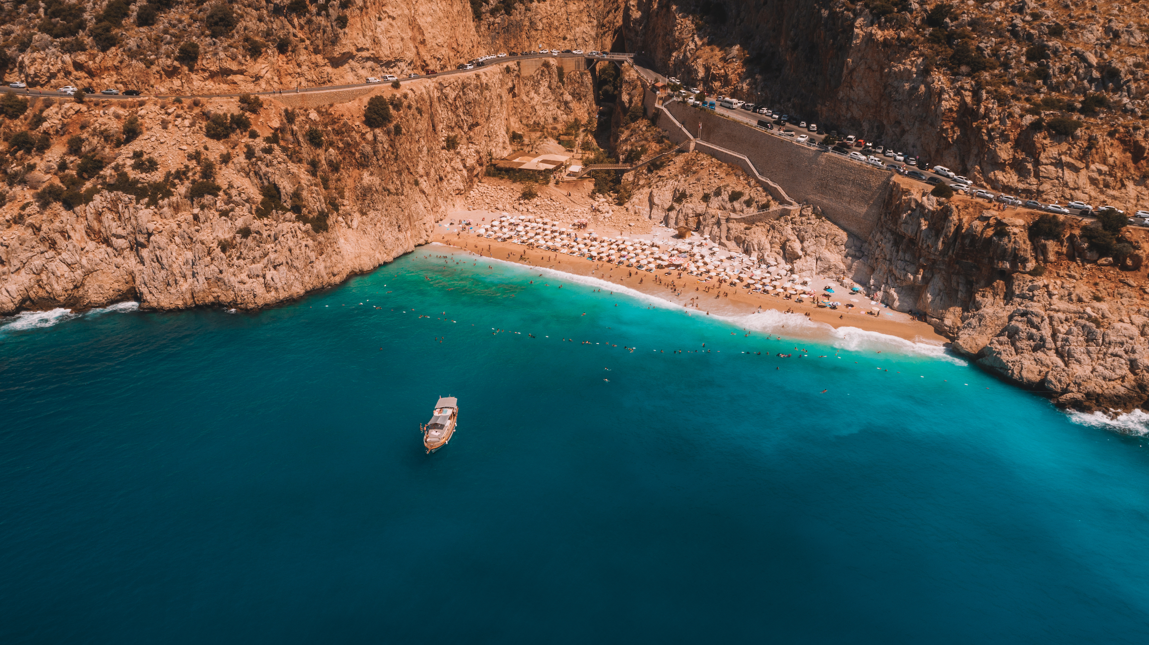 Plaża Kaputas. Ludzie cieszący się słońcem i morzem na pięknym turkusowym morzu i piaszczystej plaży Kaputas. Bird's eye view drone. Morze i niebieskie niebo w tle. Morze Śródziemne, Kas / Antalya - TURCJA