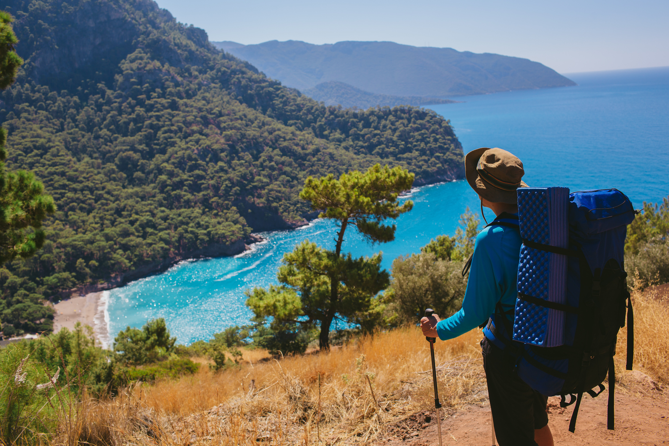 Człowiek z plecakiem relaks na szczycie góry i ciesząc się na widok zatoki Kabak i krajobrazu morskiego. Turystyka piesza podróż do Turcji, lycian sposób