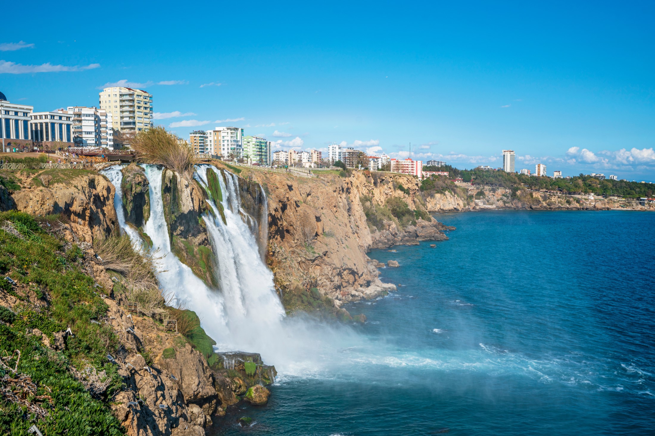 The scenic view of Düden waterfall and rainbow on a sunny day from different sea levels in Antalya