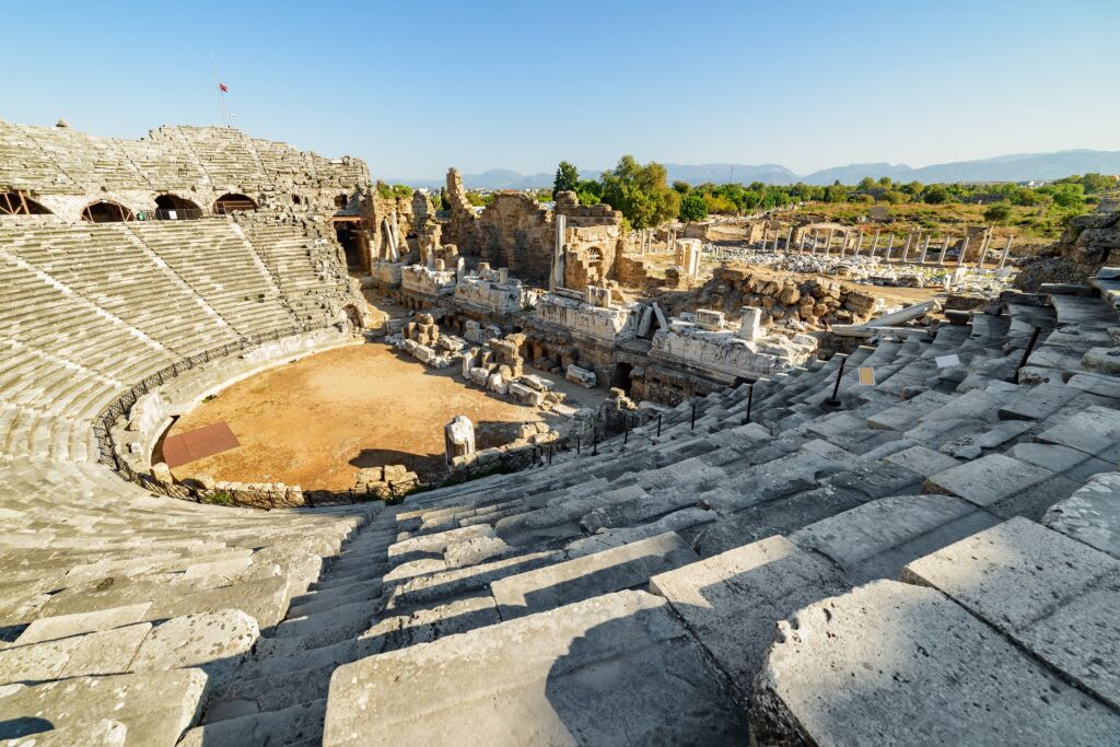 Aerial view of the ancient theatre in Side, Turkey. Drone flying around the scenic ruins. Side is a popular tourist destination in Turkey.